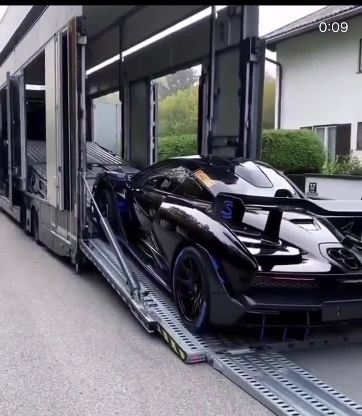 En sportbil lastas på en biltransportbil via en ramp.